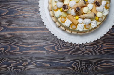 Ahşap arka plan üzerinde tatlılar ve marshmallowile süslenmiş iştah açıcı kek, kopya alanı