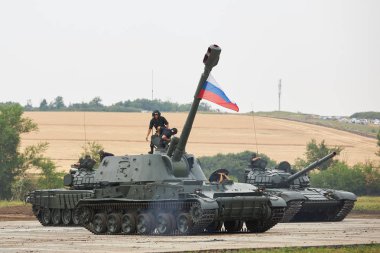 SAMBEK, ROSTOV REGION, RUSSIA, JUNE 28, 2019: International military technical forum ARMY-2019. Crew of tank get inside the self-propelled howitzer 2S3M Akatsiya clipart