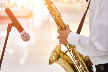 Genç caz müzisyeni büyük bir salonda saksafon çalıyor