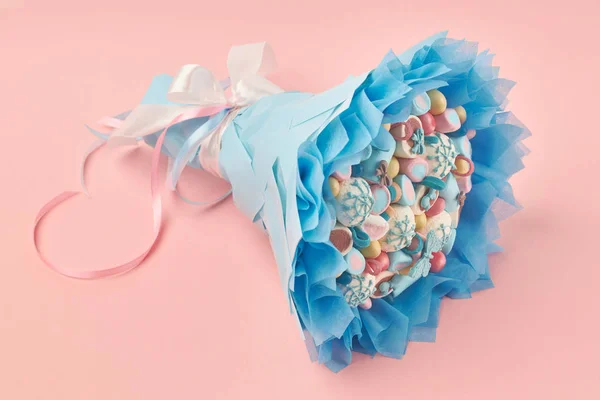 Delicious bouquet of colorful marshmallows, sweets, decorated with chocolate on a pink background as a gift to a child