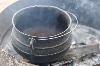 Balmumunun eridiği şenlik ateşinde eski kirli çömlek