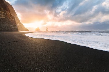 Reynisfjara ya da daha çok bilinen adıyla Kara Kum sahili gün doğumunda manzarası