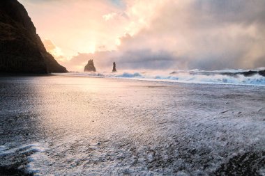 Reynisfjara ya da daha çok bilinen adıyla Kara Kum sahili gün doğumunda manzarası