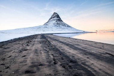 Kirkjufell, İzlanda 'nın Snaefellsnes yarımadasının kuzey kıyısında, Grundarfjordur kasabası yakınlarındaki yüksek bir dağ olan kış karları sırasında manzaraya sahiptir. 