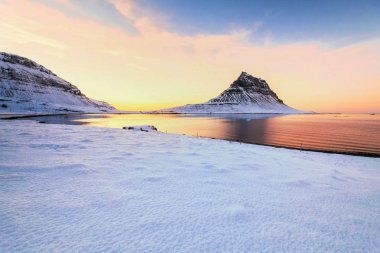 Kirkjufell, İzlanda 'nın Snaefellsnes yarımadasının kuzey kıyısında, Grundarfjordur kasabası yakınlarındaki yüksek bir dağ olan kış karları sırasında manzaraya sahiptir. 