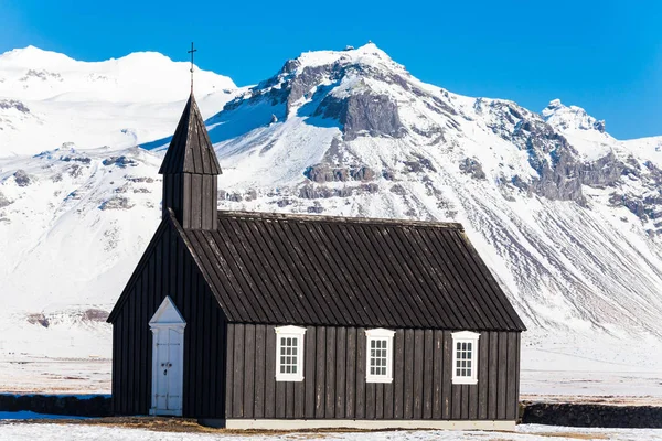 Budakirkja or better known as The Black Church view with blue sky during winter snow, Iceland
