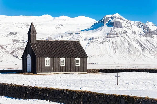 在冰岛 冬季大雪期间 布达基卡 Budakirkja 或更有名的 黑色教堂 Black Church 在蓝天下的景象 — 图库照片