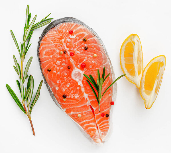 Стейк из свежей рыбы лосося с розмарином и лимоном на белом фоне. Концепция плоского слоя, морепродуктов
.
