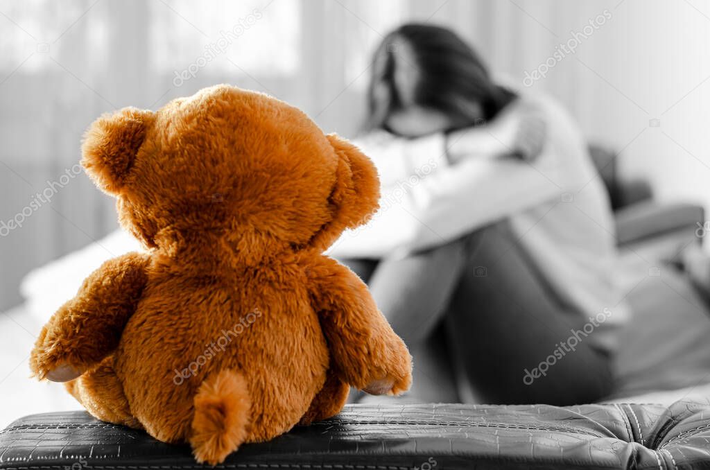 Crying woman and teddy bear. Loneliness concept
