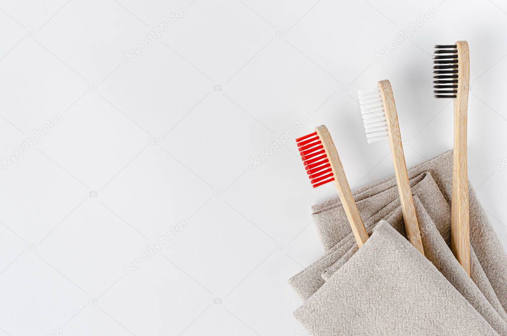 Bamboo toothbrushes on a linen towel. Flat lay, copy space.