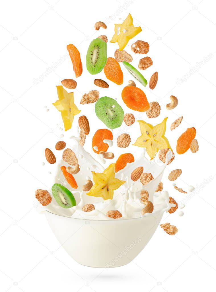 Cereal corn flakes with fruits and nuts falling into the bowl with splashing milk. Isolated on white. Healthy breakfast concept.