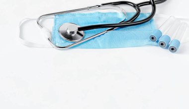 Koruyucu maskeye steteskop ve beyaz arka planda kan testi için boş konteynır. Tıbbi muayeneler. Boşluğu kopyala