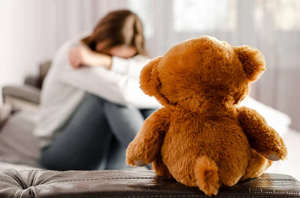 Sitting upset woman and teddy bear. Selective focus. Break up concept