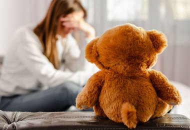 Depresyondaki ve düşünceli kadın geçmişine odaklanmış kahverengi ayıcığa odaklanmış. Kısırlık ve boşanma kavramı