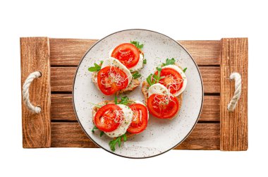 Açık sandviçli bir tabak taze mozarella, domates ve ahşap tepside roka. İtalyan yemeği konsepti. İzole, tepede..