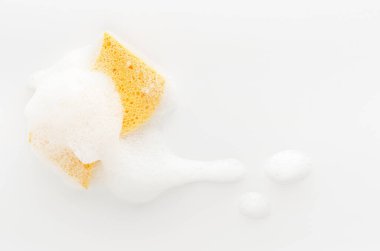 Beyaz arka planda köpüklü sarı sabunlu sünger. Temizlik konsepti. Boşluğu kopyala