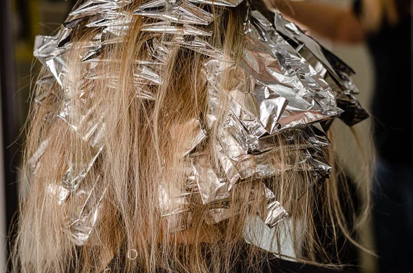 Foil on models hair. Bleaching or dyeing process. Beauty salon, fashionable hair coloring with AirTouch technique