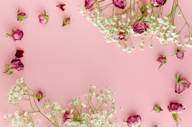 Pastel pembe arka planda tebrik kartı için güzel bir çiçek çerçevesi. Mesaj için yer var. Düz yatıyordu