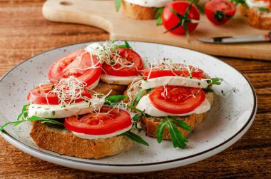 Taze mozzarella, domates ve roka ile açık sandviç. İtalyan gıda konsepti