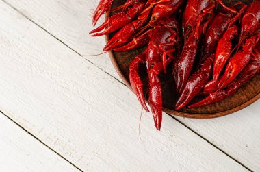 Beyaz ahşap zemin üzerinde kerevit olan bir tabak. Uzayı kopyala, seçici odaklanma. Genel giderler