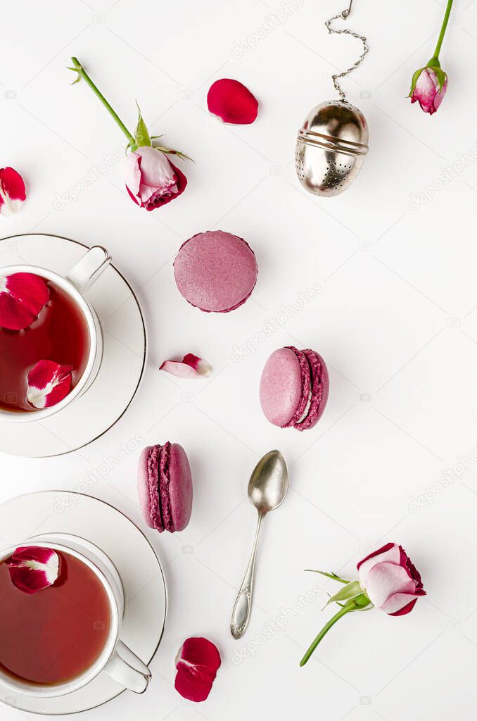 Breakfast tea on white table with roses and macaroons for two. Vallentines day and romance concept. Flat lay, top down
