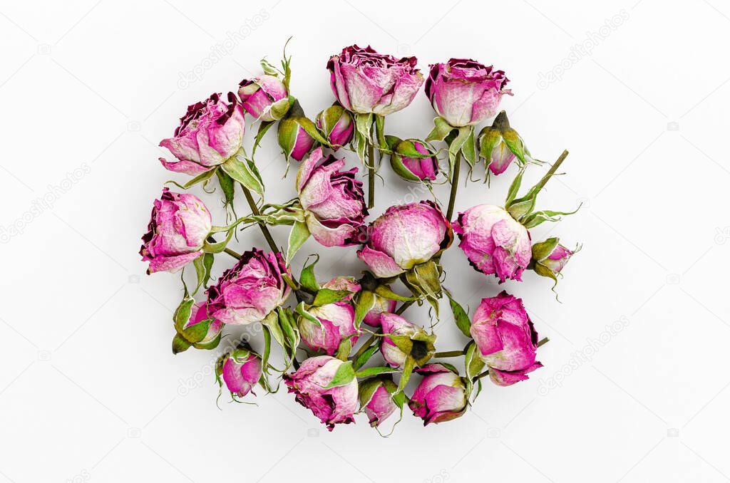 Heap of dried pink roses on white background. Overhead, top view.