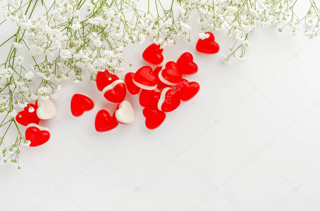 Greeting card concept. Heart shaped jelly gummies on white. Copy space. Love and romance. Top view, overhead