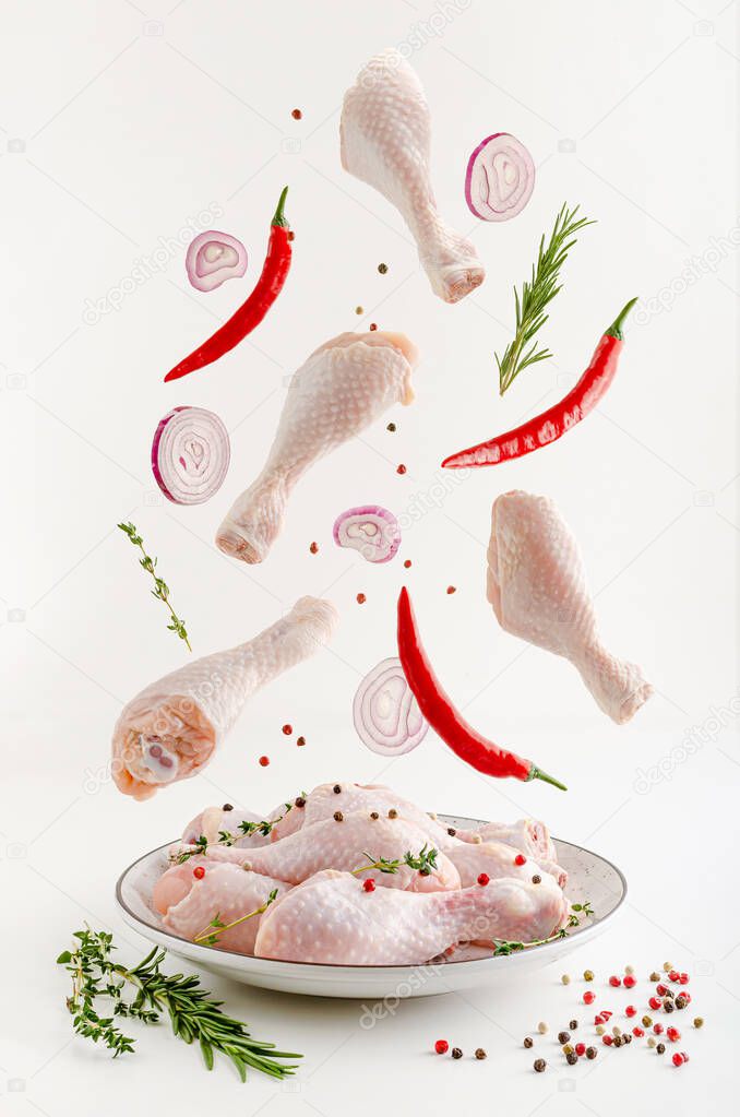 Spicy marinated raw chicken legs or drumsticks levitation. Flying food concept.