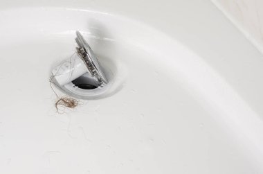 Saç dökülmesi veya saç dökülmesi konsepti. Yıkandıktan sonra duşta takunyalar. Kapat, boşluğu kopyala.