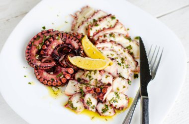 Beyaz tabakta soslu lezzetli ahtapot carpaccio. Deniz ürünleri lezzeti.