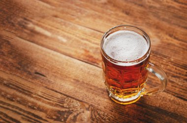 Ahşap arka planda bir bardak bira. Üst görünüm, boşluğu kopyala. Alkolik içecekler