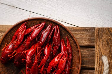 Beyaz ahşap zemin üzerinde kerevit olan bir tabak. Uzayı kopyala, seçici odaklanma. Genel giderler