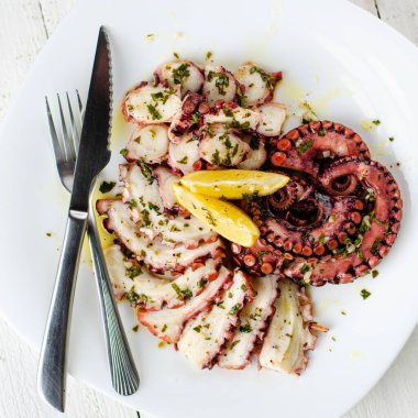 Beyaz tabakta soslu lezzetli ahtapot carpaccio. Deniz ürünleri lezzeti. Genel olarak, kare resim
