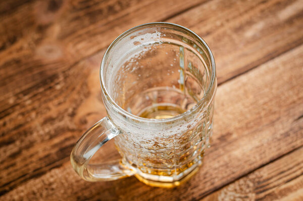 Empty glass of beer on wooden rustic background. Top view. Alcoholism concept