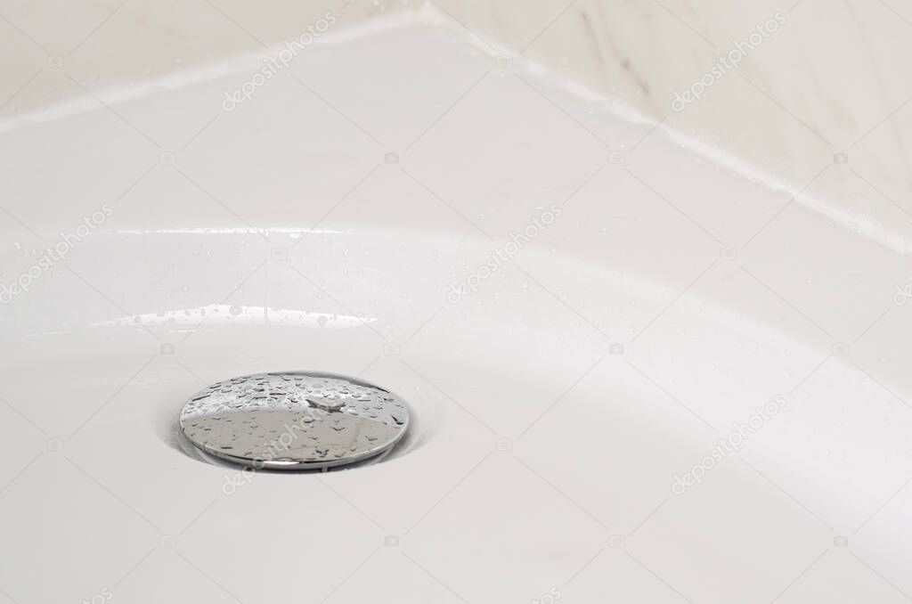 Shower tray and water tap or drain plug with drops of water. Fungus cleaning concept.