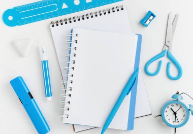 Not defteri ve kırtasiye malzemesi beyaz masaüstünde. Eğitim konsepti. Model, tam üstte..