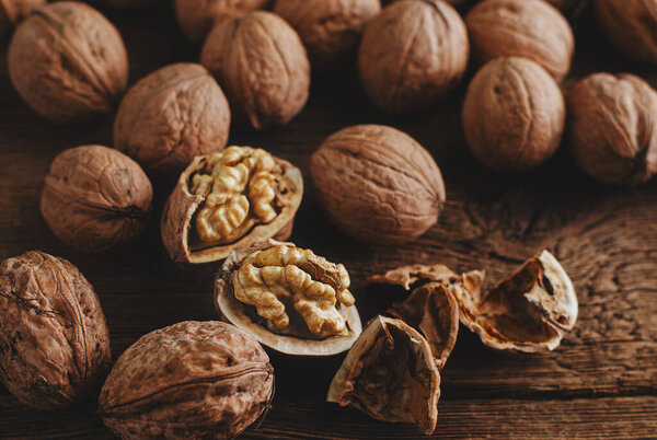 Walnut kernels in a shell on rustic wooden table. Healthy eating,