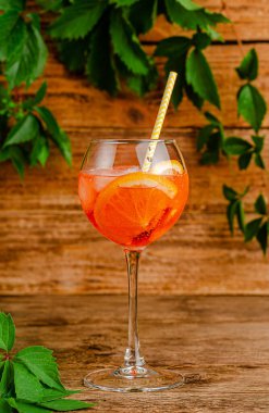 Kırsal ahşap arka planda saman içilen Aperol spritz kokteyli..