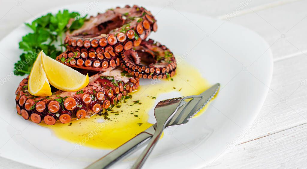 Octopus salad with dressing, lemon and parsley on white background. Healthy eating. Seafood concept