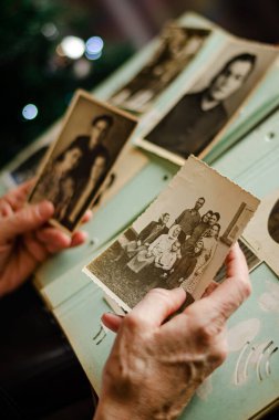 Cherkasy / Ukrayna - 12 Aralık 2019: kadın el ele tutuşması ve akrabalarının eski fotoğrafları. Fotoğraflı klasik fotoğraf albümü. Aile ve yaşam değerleri kavramı.