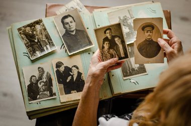 Cherkasy / Ukrayna - 12 Aralık 2019: kadın el ele tutuşması ve akrabalarının eski fotoğrafları. Fotoğraflı klasik fotoğraf albümü. Aile ve yaşam değerleri kavramı.