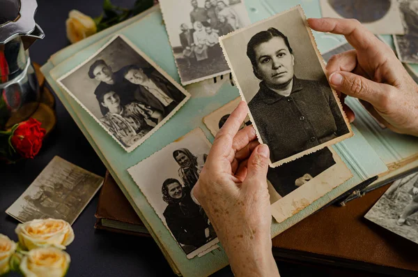 Cherkasy / Ukrayna - 12 Aralık 2019: kadın el ele tutuşması ve annesinin eski fotoğrafı. Fotoğraflı klasik fotoğraf albümü. Aile ve yaşam değerleri kavramı.