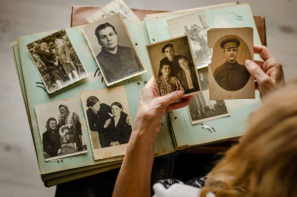 Cherkasy / Ukrayna - 12 Aralık 2019: kadın el ele tutuşması ve akrabalarının eski fotoğrafları. Fotoğraflı klasik fotoğraf albümü. Aile ve yaşam değerleri kavramı.