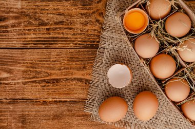 Ahşap arka planda çiğ yumurta. Yukarıdan, boşluğu kopyala.