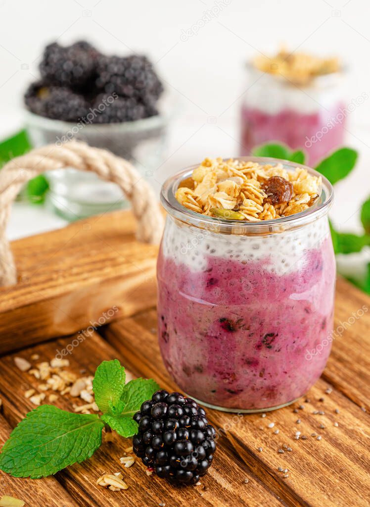 Chia yogurt jar of granola and blackberries. Healthy breakfast concept