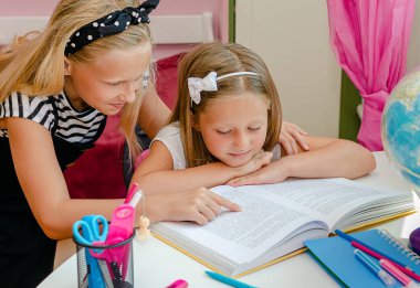 Ablam anaokulu ablasının kitap okumasına yardım eder. Eğitim