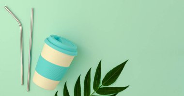 Yeniden kullanılabilir bambu eko bardak ve yeşil arka planda metalik pipet içme. Üst görünüm, boşluğu kopyala. Sıfır atık