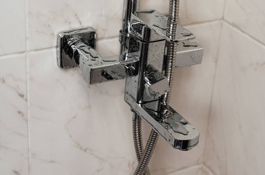 Islak su musluğu ya da duş kabininde duvara musluk dayamak. Boşluğu kopyala