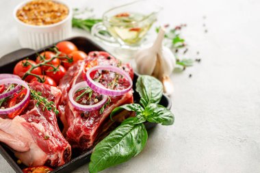 Beton arka planda sebzeli, otlu ve baharatlı taze dana eti bifteği. Seçici odak, boşluğu kopyala