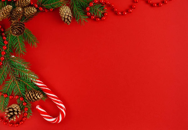 Kırmızı arka planda şeker kamışlı Noel kompozisyonu. Üst görünüm
